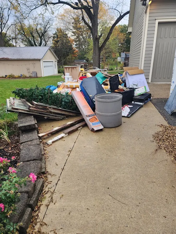 Dumpster being loaded with debris for Estate Cleanout Dumpster Rental in University Center